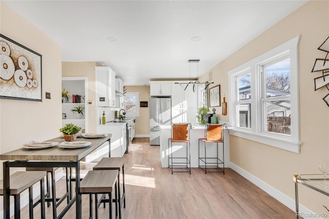 dining room featuring sink and light wood-type flooring