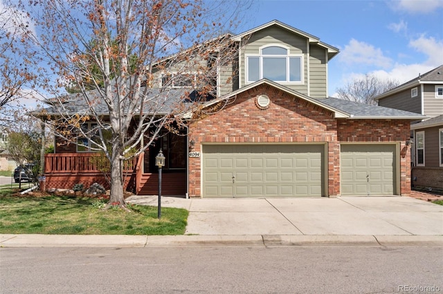 traditional-style house with brick siding, driveway, a shingled roof, and a garage