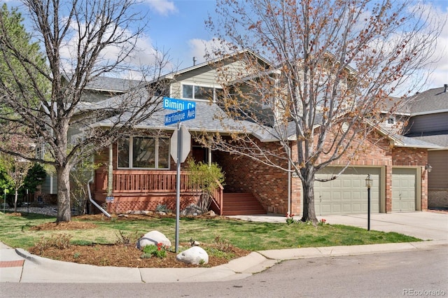 craftsman house featuring a balcony, driveway, a front yard, a garage, and brick siding