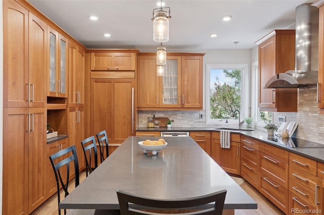 kitchen featuring black electric cooktop, a center island, light wood-style flooring, tasteful backsplash, and wall chimney range hood