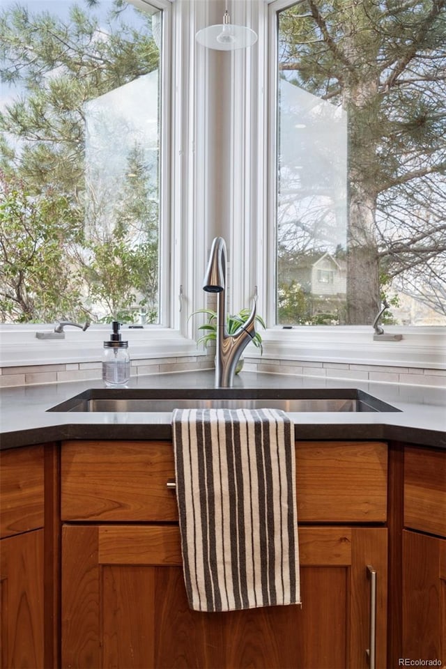 room details featuring brown cabinets, dark countertops, and a sink