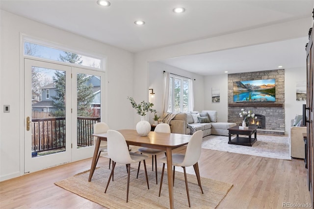dining space with recessed lighting, light wood-style floors, and a fireplace