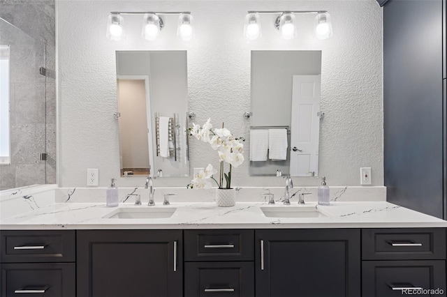 full bathroom featuring a textured wall, a sink, and double vanity