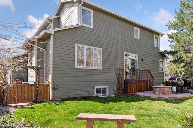 back of house with a yard, a hot tub, a patio, and fence