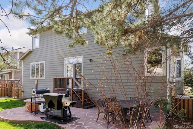 rear view of property with fence and a patio