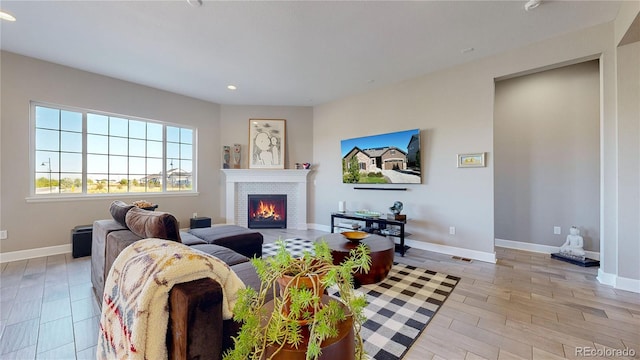 living room featuring light hardwood / wood-style floors and a brick fireplace