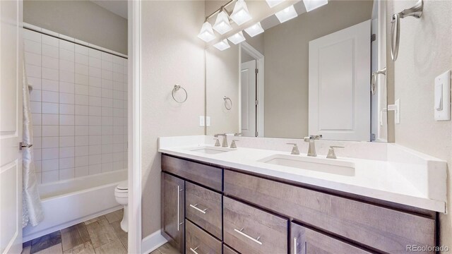 full bathroom with hardwood / wood-style floors, vanity, toilet, and shower / bathtub combination with curtain