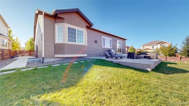 rear view of property with outdoor lounge area, a lawn, and a patio