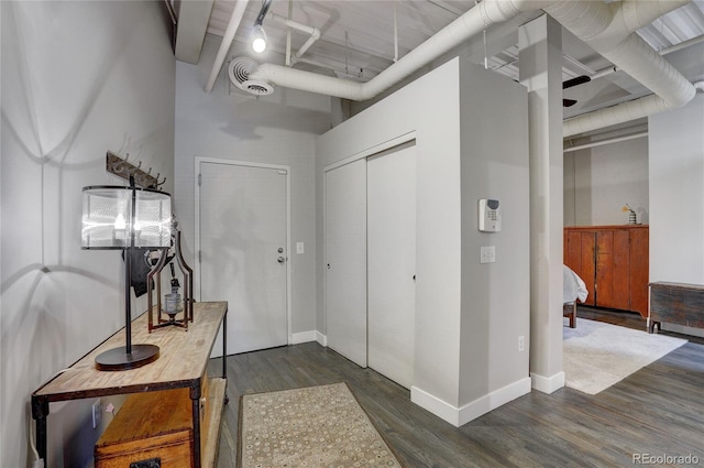 foyer entrance with a towering ceiling, baseboards, visible vents, and dark wood finished floors