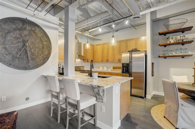 kitchen featuring stainless steel refrigerator with ice dispenser, backsplash, light stone countertops, dark wood finished floors, and rail lighting