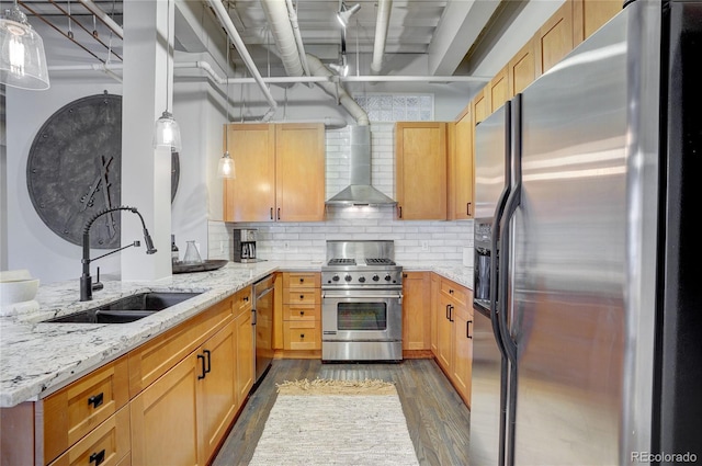 kitchen featuring dark wood-style floors, wall chimney exhaust hood, light stone countertops, stainless steel appliances, and a sink