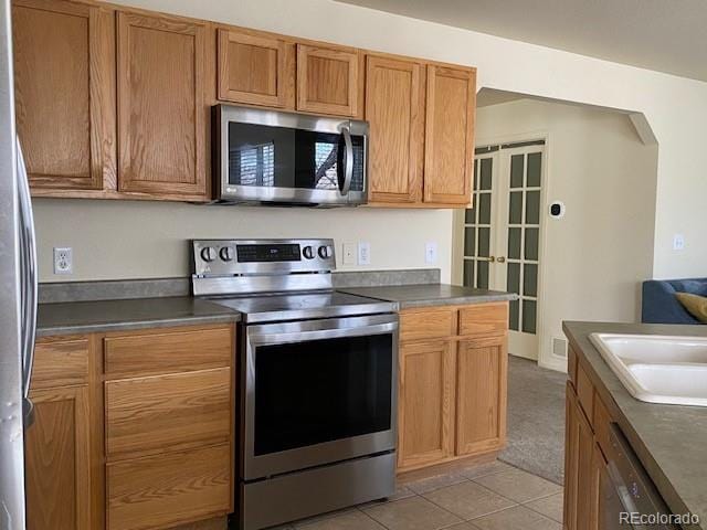 kitchen featuring appliances with stainless steel finishes, light tile patterned floors, and sink