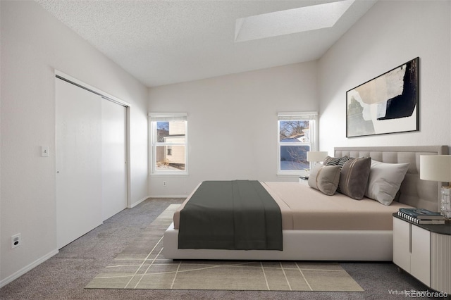 carpeted bedroom featuring lofted ceiling with skylight, multiple windows, and a textured ceiling