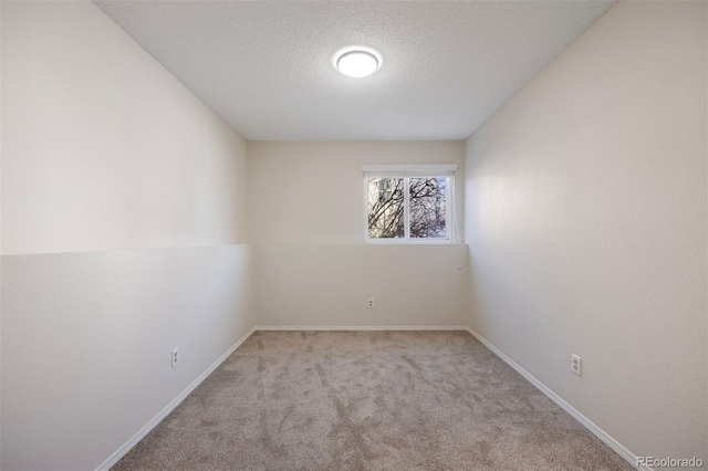 carpeted empty room with a textured ceiling