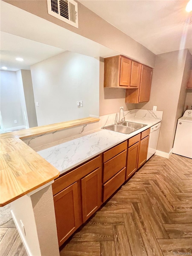 64 Nome Way Unit C, Aurora, CO 80012 - kitchen with white dishwasher, a sink, washer / dryer, and light countertops