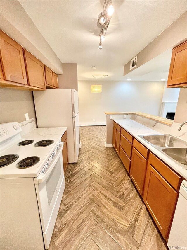 64 Nome Way Unit C, Aurora, CO 80012 - kitchen with white appliances, a sink, light countertops, and brown cabinets