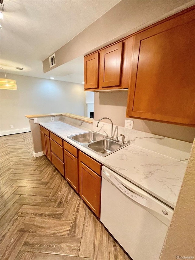 64 Nome Way Unit C, Aurora, CO 80012 - kitchen featuring dishwasher, a sink, brown cabinetry, light countertops, and baseboards