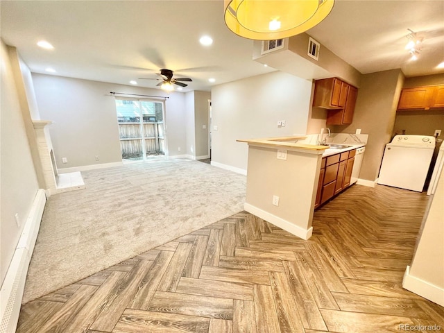 64 Nome Way Unit C, Aurora, CO 80012 - kitchen featuring washer / clothes dryer, a sink, brown cabinets, baseboards, and recessed lighting