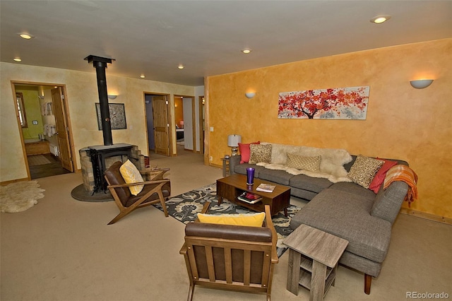 living room with a wood stove and light colored carpet