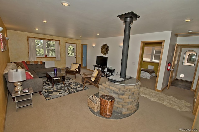 carpeted living room featuring a wood stove