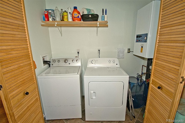 clothes washing area featuring water heater, washing machine and dryer, and tile patterned flooring