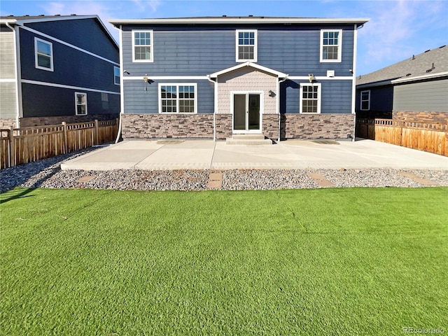 rear view of property featuring entry steps, a patio area, a lawn, and fence