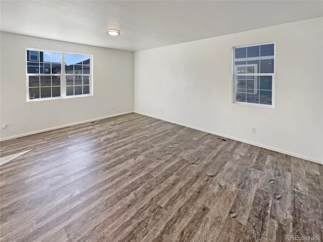 unfurnished room featuring baseboards and wood finished floors