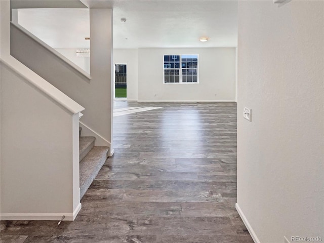 interior space with stairs, baseboards, and wood finished floors