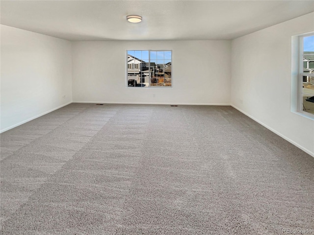 spare room featuring carpet and baseboards