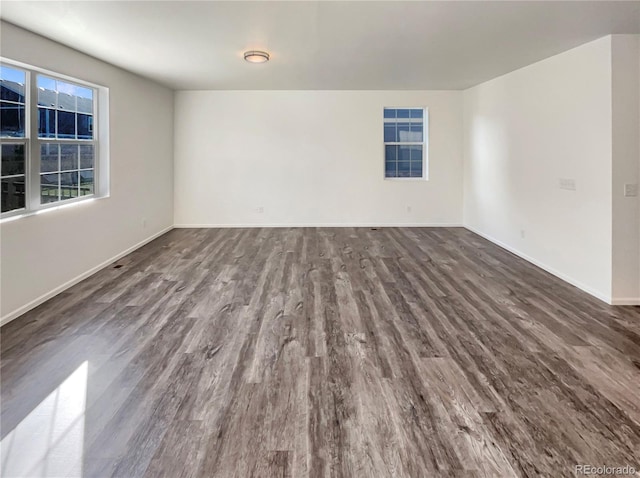 unfurnished room with baseboards and dark wood-style flooring