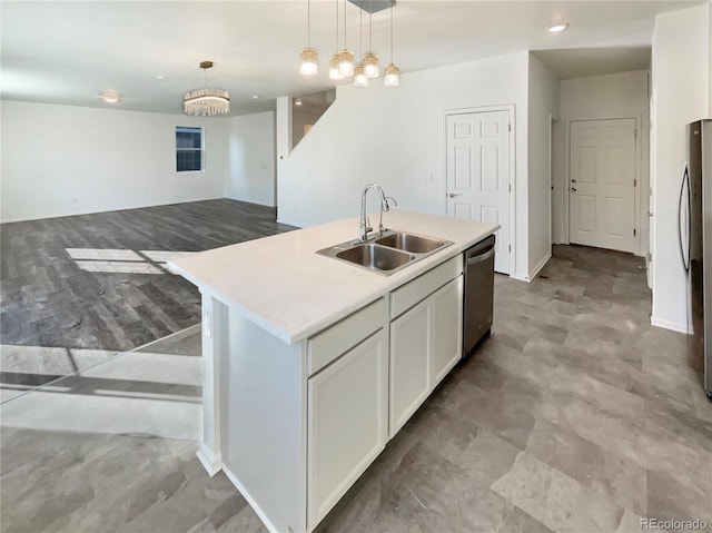 kitchen featuring appliances with stainless steel finishes, pendant lighting, a sink, and light countertops