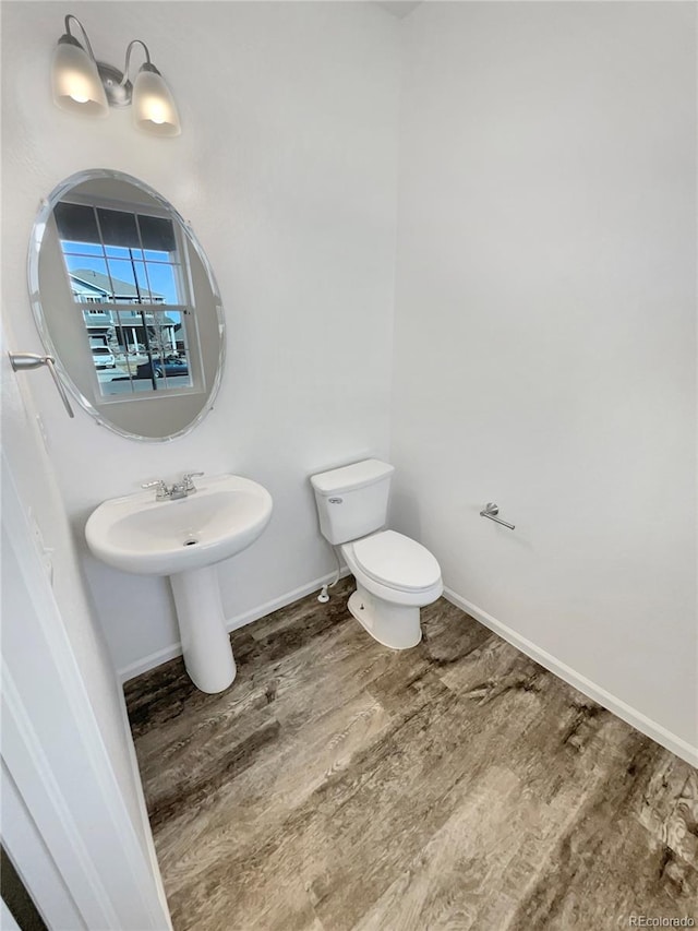 bathroom featuring wood finished floors, toilet, and baseboards