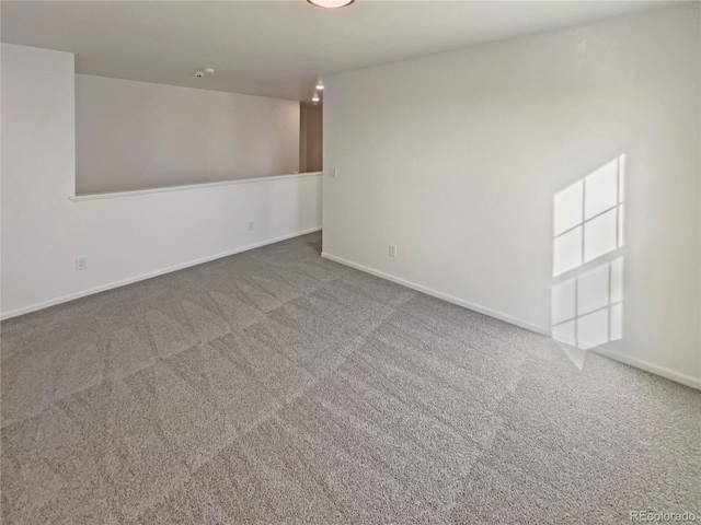 empty room featuring carpet flooring and baseboards