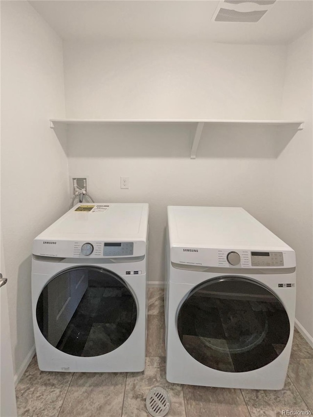 washroom with washer and dryer, laundry area, and baseboards