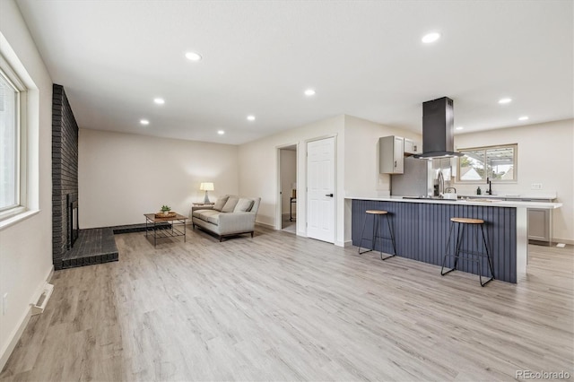 7952 Zuni St, Denver, CO 80221 - living room featuring light wood-style floors, recessed lighting, baseboards, and a fireplace