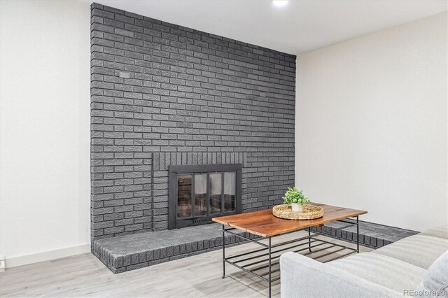 7952 Zuni St, Denver, CO 80221 - living room with wood finished floors, a brick fireplace, and baseboards