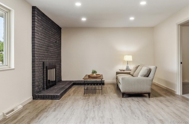 7952 Zuni St, Denver, CO 80221 - sitting room with wood finished floors, a brick fireplace, recessed lighting, and baseboards