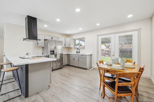 7952 Zuni St, Denver, CO 80221 - kitchen featuring wall chimney exhaust hood, stainless steel refrigerator with ice dispenser, gray cabinets, french doors, and light wood finished floors