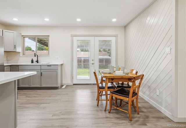 7952 Zuni St, Denver, CO 80221 - dining room with light wood finished floors, french doors, recessed lighting, wood walls, and baseboards