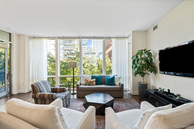 living room with dark wood-type flooring, floor to ceiling windows, and a healthy amount of sunlight