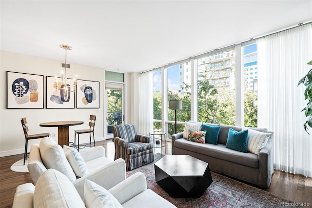 living room with baseboards, dark wood-type flooring, a notable chandelier, and floor to ceiling windows