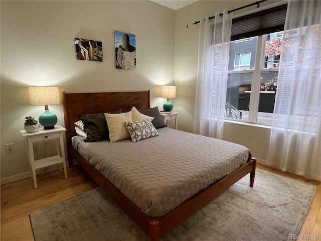 bedroom with wood finished floors and baseboards