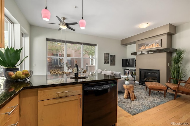 kitchen featuring ceiling fan, decorative light fixtures, light hardwood / wood-style flooring, dark stone countertops, and black dishwasher