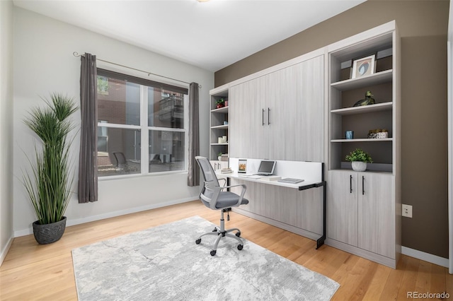 home office featuring baseboards and light wood finished floors