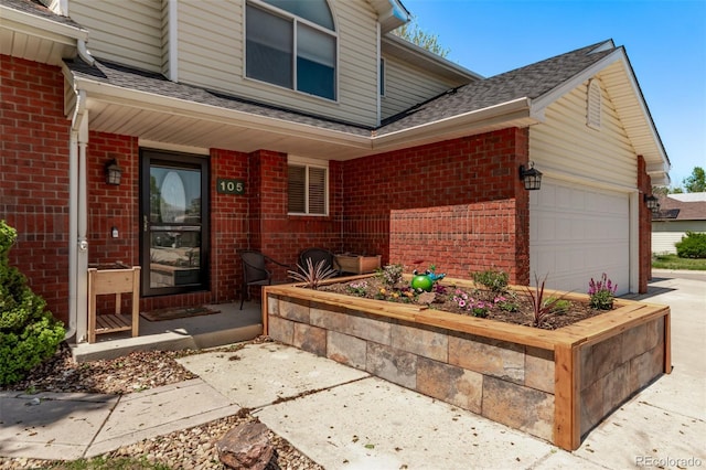 105 Hawthorn St, Frederick, CO 80530 - property entrance featuring brick siding, a shingled roof, a garage, and concrete driveway