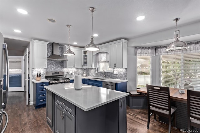 105 Hawthorn St, Frederick, CO 80530 - kitchen featuring wall chimney range hood, stainless steel appliances, blue cabinetry, light countertops, and recessed lighting