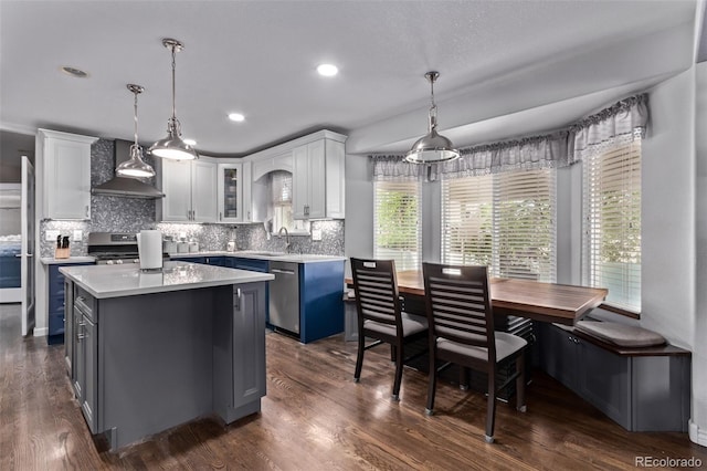 105 Hawthorn St, Frederick, CO 80530 - kitchen featuring wall chimney exhaust hood, a sink, light countertops, white cabinets, and decorative backsplash