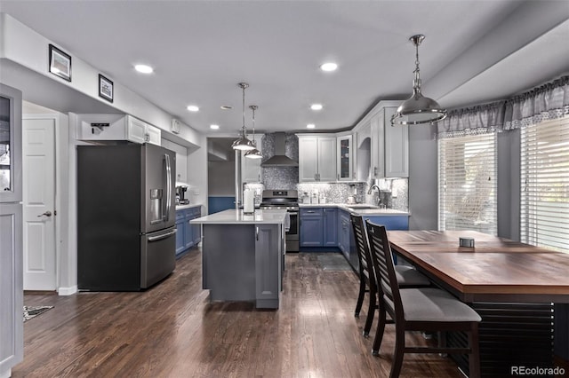 105 Hawthorn St, Frederick, CO 80530 - kitchen with stainless steel appliances, wall chimney exhaust hood, a sink, dark wood-style floors, and a center island