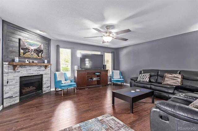 105 Hawthorn St, Frederick, CO 80530 - living room featuring hardwood / wood-style flooring, a ceiling fan, a stone fireplace, and baseboards