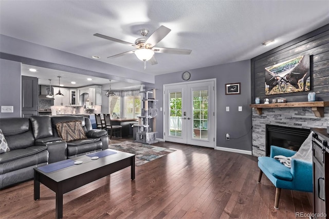 105 Hawthorn St, Frederick, CO 80530 - living area with baseboards, a ceiling fan, a stone fireplace, french doors, and dark wood-style floors